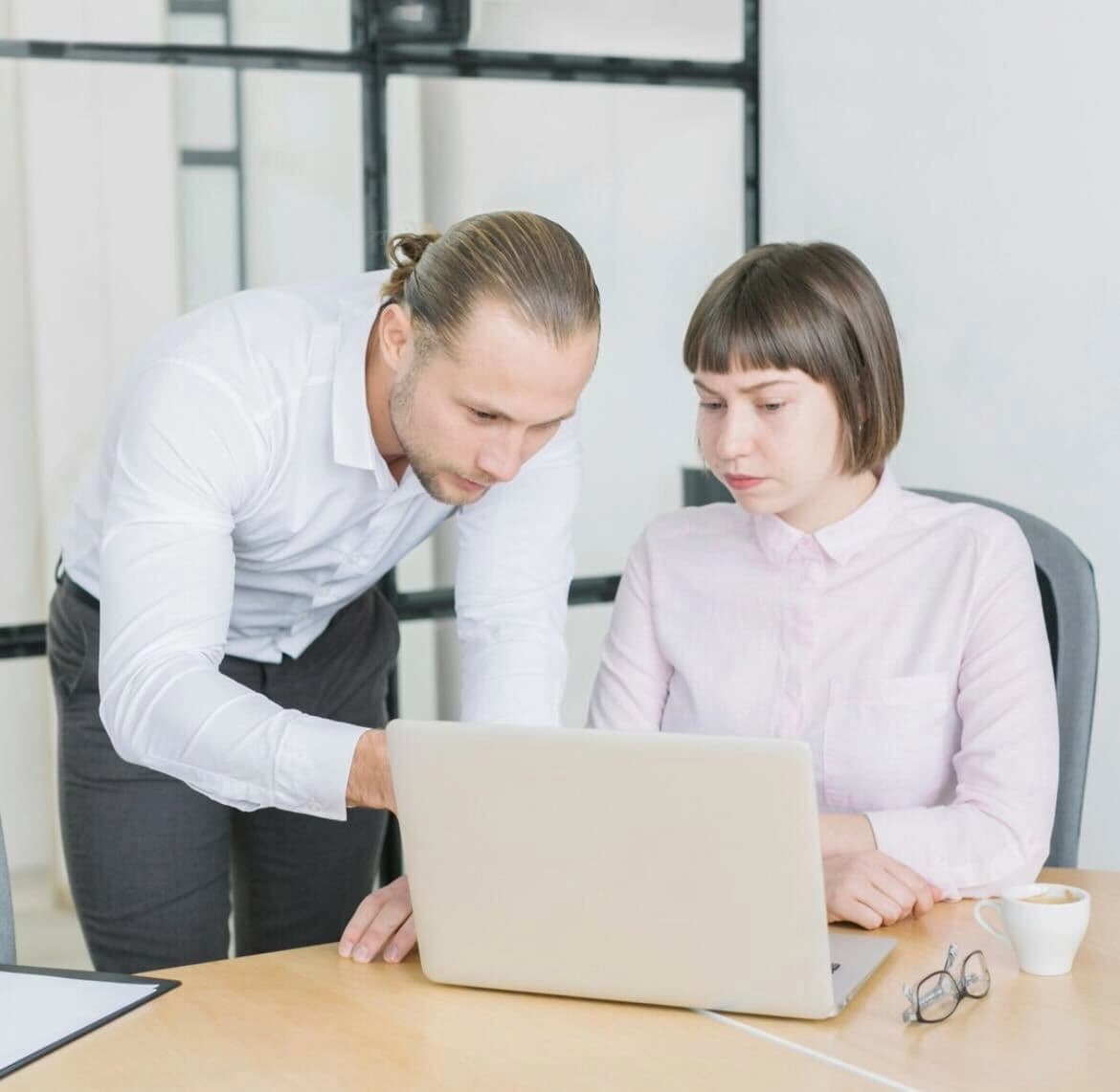 Programer pregledava kod na monitoru sa kolegama