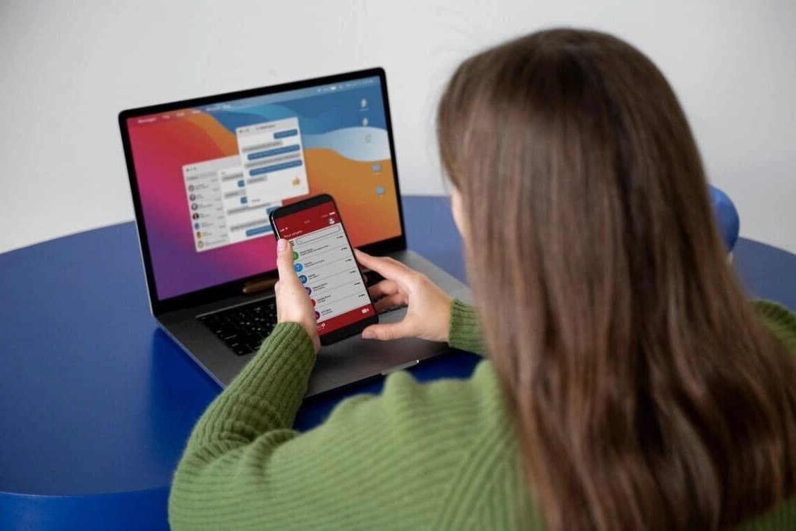 Developer mijenja kod na laptop-u dok se promjene instantno prikazuju na mobilnom uređaju